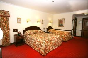 um quarto de hotel com duas camas e um tapete vermelho em Dorrians Imperial Hotel em Ballyshannon
