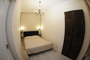 a small bedroom with a bed and a mirror at Poarta Ecaterina Residence in Braşov