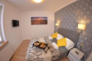 una camera da letto con un letto e un vassoio di cibo sopra di Apartament City Center Platinum - Luxury Standard a Krynica-Zdrój