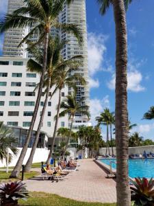 un complejo con piscina con palmeras y un edificio alto en Miami Beach Suncoast Apartment I - Balcony Front Beach, en Miami Beach