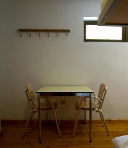 a table and two chairs in a room at Albergue Montes de Anaga in El Bailadero