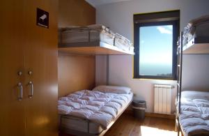 a room with two bunk beds and a window at Albergue Montes de Anaga in El Bailadero