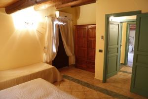 1 dormitorio con 2 camas y puerta verde en Albergo La Fontanella, en Noto