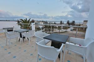 un patio con mesas y sillas y vistas al océano en Riad Diamant Blanc en Essaouira