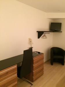 a room with a desk and a chair and a tv at Chambres d'hotes Karine SMEJ in Châtillon-sur-Marne
