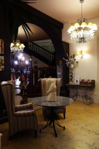 a living room with a table and chairs and a staircase at LOGIS Hôtel de Bourgogne - Mâcon in Mâcon