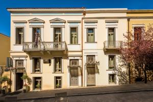 Un grand bâtiment blanc avec balcon est disponible. dans l'établissement Maison Grecque Hotel Extraordinaire, à Patras