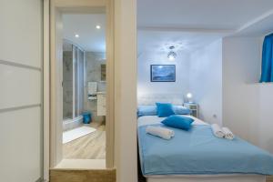 1 Schlafzimmer mit einem blauen Bett und einem Badezimmer in der Unterkunft Apartman Gloria in Dubrovnik