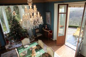 a dining room with a christmas tree and a chandelier at Chateau du Mur in Comblessac