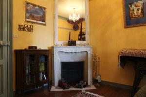 a living room with a fireplace and a mirror at Chateau du Mur in Comblessac