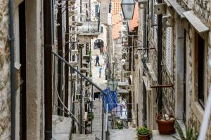 Eine Gasse in einer alten Stadt mit Leuten, die sie entlanglaufen. in der Unterkunft Apartman Gloria in Dubrovnik