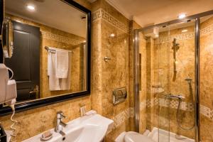 a bathroom with a sink and a shower at Maison Grecque Hotel Extraordinaire in Patra