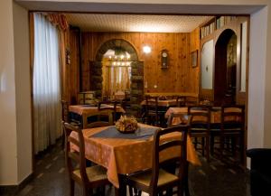 een eetkamer met tafels en stoelen en houten wanden bij Hotel Napoleon in Montjovet