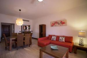 a living room with a red couch and a table at Tot Punta Cana Apartments in Punta Cana