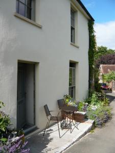 a table and chairs sitting outside of a white house at The Tall House in Totnes