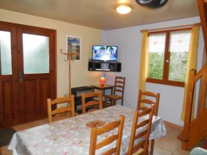 a dining room with a table and chairs and a television at Les Gîtes de Galinette in La Bâtie-Vieille