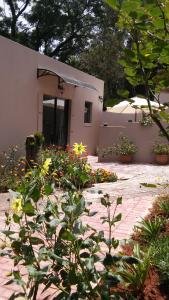 a garden with flowers in front of a building at @Home Cottage in Johannesburg