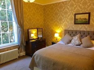 a bedroom with a bed and a mirror and a window at Ashdale Guesthouse in Matlock +34 photos