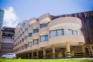 um edifício com um carro estacionado em frente em Marsallis Praia Hotel em Natal