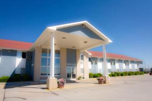 un gran edificio blanco con techo rojo en Alliance Hotel and Suites en Alliance