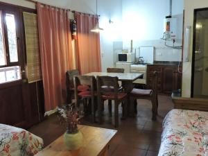 cocina y comedor con mesa y sillas en Cabañas de la Colina en Villa General Belgrano