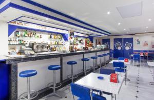 a bar in a restaurant with blue stools at Hostal Pardo in Miami Platja