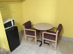 cocina con mesa, 2 sillas y microondas en Blue Star Inn, en Odessa