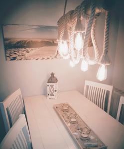 a dining room table with two chairs and a chandelier at Strandgut - das appartement in Schönhagen