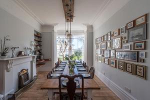 a dining room with a long table with chairs at Holbein House in Penzance