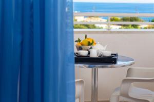 - une table avec un bol de fruits et des tasses dans l'établissement Primavera Paradise Apartments, à Agios Nikolaos