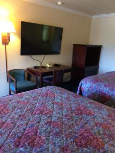 a hotel room with a bed and a tv at Oak Motel in Palo Alto