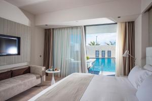 a hotel room with a large bed and a couch at Aqua Blu Boutique Hotel & Spa, Adults Only in Kos +50 photos