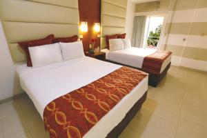 um quarto de hotel com duas camas e uma janela em Minister Business Hotel em Tegucigalpa