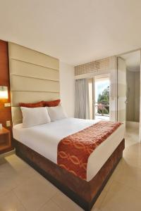 a bedroom with a large bed and a balcony at Minister Business Hotel in Tegucigalpa