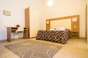 a bedroom with a bed and a desk and a chair at Ariston Vacanze in Marina di Ravenna