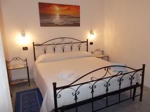 a bedroom with a large bed with white sheets at B&B S'Apposentu in Arbus