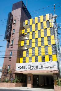 a hotel building with yellow shutters on it at Hotel Double Funabashi in Funabashi