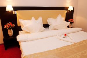 Una habitación de hotel con una cama con una rosa. en Pension Siera, en Mamaia Nord – Năvodari