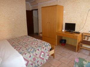 Schlafzimmer mit einem Bett und einem Schreibtisch mit einem Computer in der Unterkunft Hotel Bolognese in Foligno