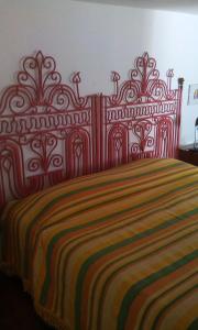CannoleにあるCasa Paolaの大型ベッド(赤と黄色のベッドカバー付)
