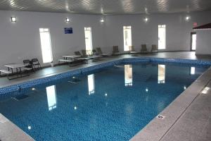 a large swimming pool with chairs and tables in a building at Spring Water Hotel & Suites in Cuauhtémoc