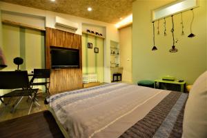 a bedroom with a bed and a flat screen tv at Macaron B&B in Luodong