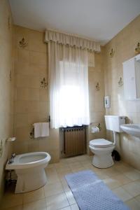 a bathroom with a toilet and a sink at Hotel Napoleon in Montjovet