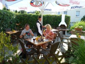 a group of people sitting at a table at a restaurant at Hotel Koos in Putbus