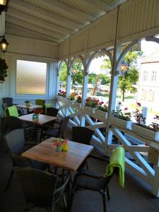 a restaurant with tables and chairs and windows at Hotel Koos in Putbus