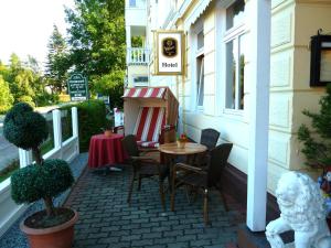a patio with a table and chairs outside of a building at Hotel Koos in Putbus