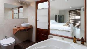 a bathroom with a sink and a toilet and a bed at Casabierta in Buenos Aires