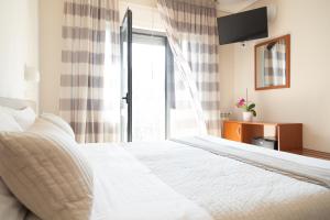 Hotel Fabbrini في أبادييا سان سالفاتور: غرفة نوم بسرير ابيض ونافذة