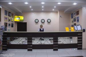 une femme debout au comptoir dans une salle d'attente dans l'établissement Bryansk Hotel, à Briansk