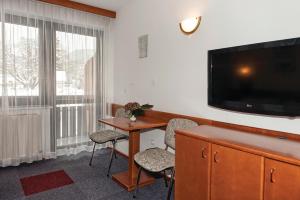 a hotel room with a desk and a flat screen tv at Hotel Tripič, restaurant and pizzeria in Bohinj